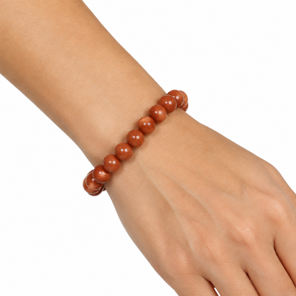 Bransoletka Golden Sand Stone na nadgarstku modelki, biale tlo